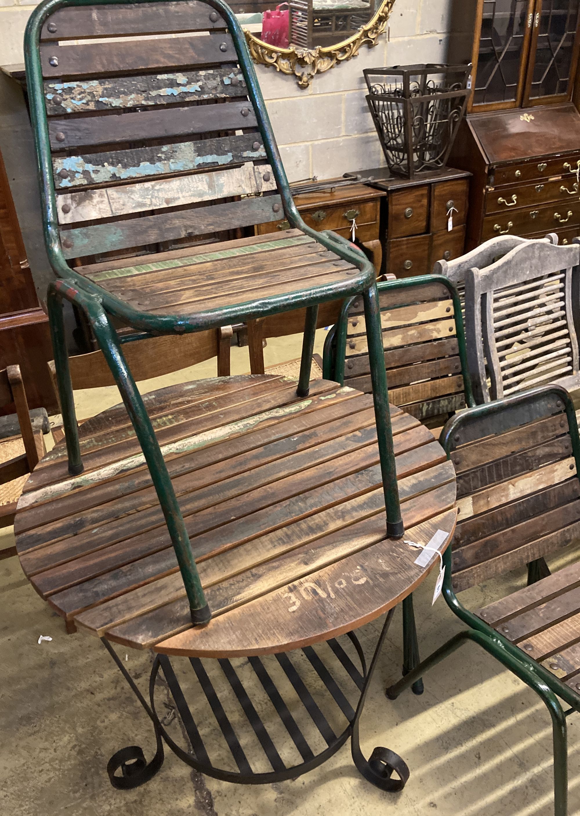 A circular slatted wood and wrought iron garden table, 85cm diameter, height 78cm together with a set of four slatted metal stacking ga